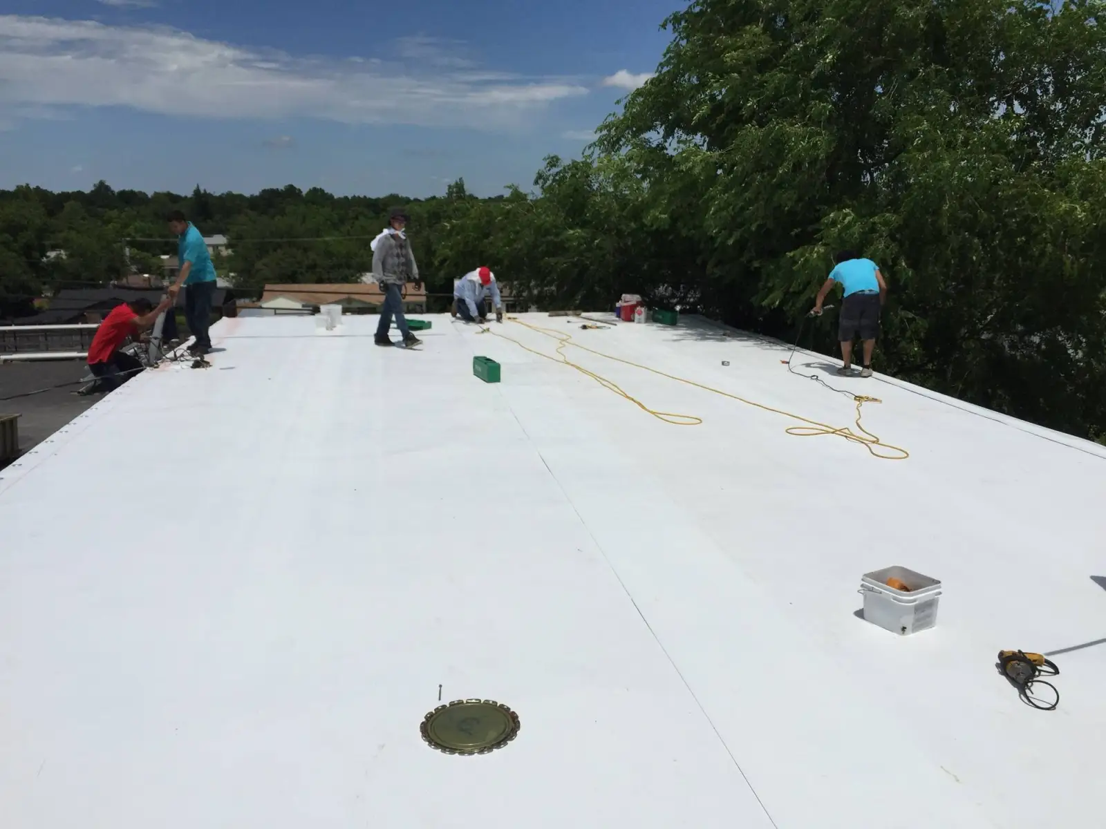 Crew on a new white roof on 11th Street