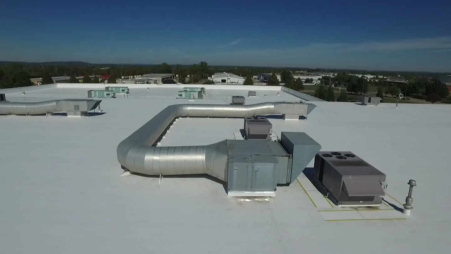 Large white commercial roof with rooftop ductwork