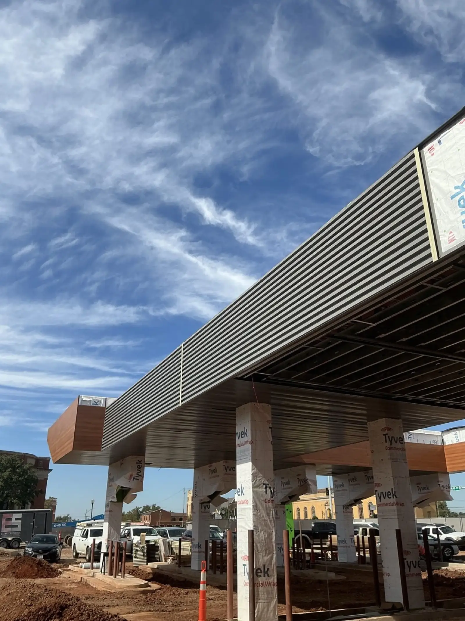 Canopy with ribbed metal fascia and wood-grain soffit