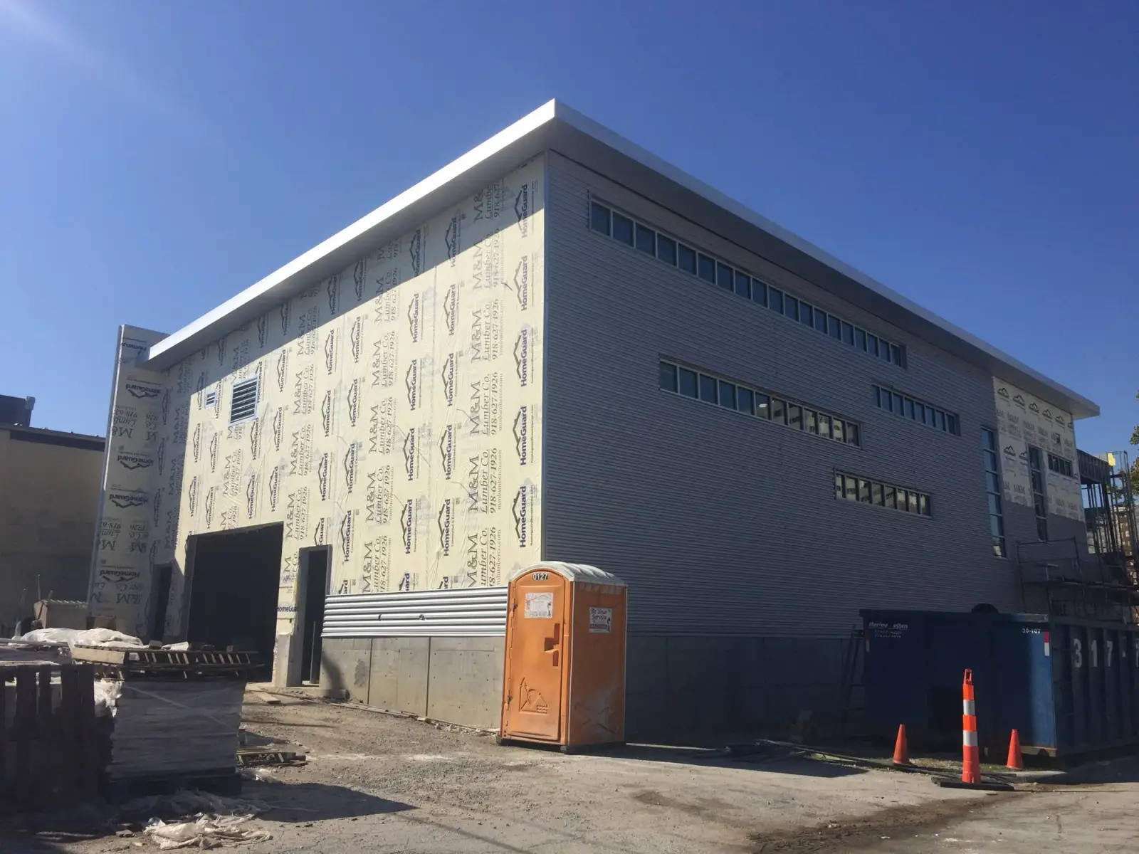 Crew installing metal wall panels at 16th and Boston